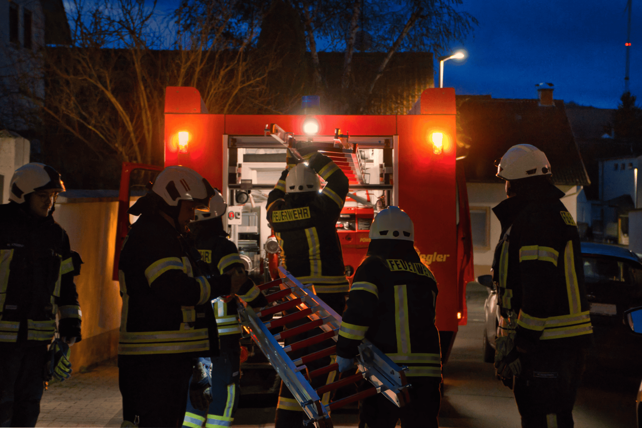 Die Mannschaft nach dem Einsatz beim zurückbauen. Die Leiterteile wurden getrennt und werden im Tanklöschfahrzeug verstaut.